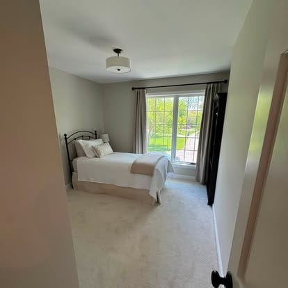 Bedroom with sliding glass door, new carpet, neutral paint and a flush ceiling light