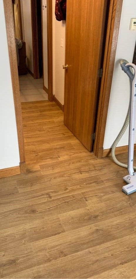 Hallway with new wood-look laminate plank flooring, oak doors and oak trim